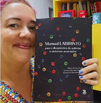 Profissional segurando o Manual LABIRINTO para o diagnóstico de autismo e sintomas associados.