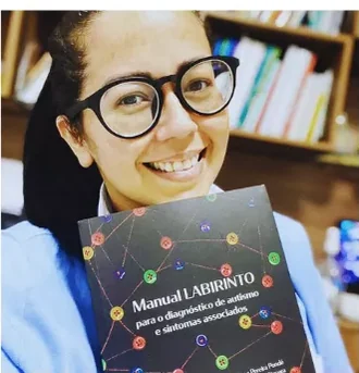 Outra profissional certificada segurando o Manual LABIRINTO.